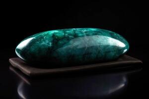 Jade is a rare precious natural geological stone eremite on a black background in low key. . photo