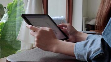 A woman uses a tablet to connect to the internet for news updates and social media. concept of living with modern technology on vacation. video