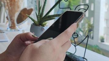 femme en utilisant téléphone intelligent dans café magasin relier à le l'Internet à suivre et mise à jour nouvelles et social médias. concept de vivant avec moderne La technologie sur vacances. video