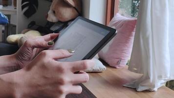 woman using tablet in coffee shop Connect to the Internet to follow and update news and social media. concept of living with modern technology on vacation. video