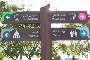 Direction sign boards in seaside,wayfinding boards,Arabic and English sign ,wooden sign boards for mosque,toilet,playground photo