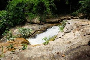 Waterfall and stream on the rock of tropical rainforest in national park at Thailand photo