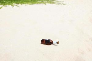 espíritu botella es basura en el playa y es un global calentamiento problema foto