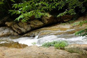 Waterfall and stream on the rock of tropical rainforest and evergreen forest in national park at Thailand photo