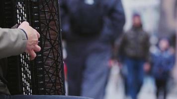 Man playing accordion by the side of the Crowded Street video