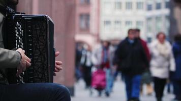 Man playing accordion by the side of the Crowded Street video