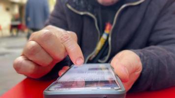 Man surfing internet by swiping his mobile phone screen with his finger video