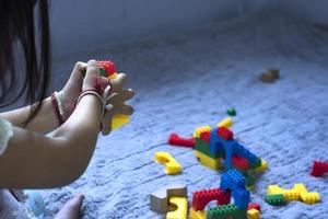 Asian woman builds a house from plastic blocks The concept of promoting the development of kindergarten children. photo