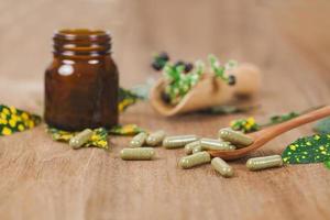 herbario medicina cápsulas desde hierba en rústico de madera mesa para sano comiendo y bueno vida ,suave enfocar. foto