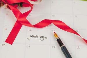 recordatorio Boda día en calendario planificación y fuente bolígrafo con color tono. foto