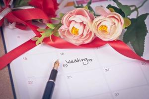 recordatorio Boda día en calendario planificación y fuente bolígrafo con color tono. foto