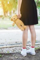 bear toy in hand of teenage girl . photo