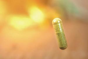 Herbal medicine capsule from herb on blur background .soft focus. photo