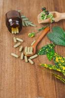 Herbal medicine capsules spilling out of a bottle ,soft focus. photo