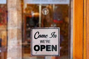 ven en, fueron abierto firmar en un Tienda ventana foto