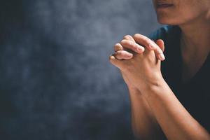 manos doblada en oración en un santo Biblia en Iglesia concepto para fe, espiritualidad y religión, mujer Orando en santo Biblia en el Mañana. mujer mano con Biblia Orando. foto