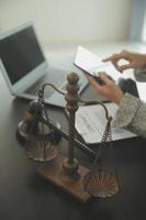 Justice and Law concept. Legal counsel presents to the client a signed contract with gavel and legal law or legal having team meeting at law firm in background photo