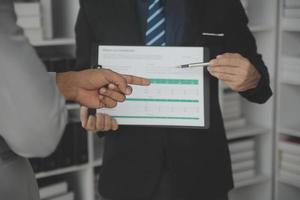 Financial analysts analyze business financial reports on a digital tablet planning investment project during a discussion at a meeting of corporate showing the results of their successful teamwork. photo