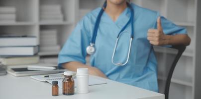 Male doctor standing with thumbs up sign in clinic near his working place. Perfect medical service in hospital. Medicine and healthcare concept photo