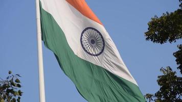 India flag flying high at Connaught Place with pride in blue sky, India flag fluttering, Indian Flag on Independence Day and Republic Day of India, tilt up shot, Waving Indian flag, Har Ghar Tiranga video