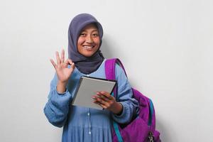 Young Asian girl student wearing hijab and backpack on white background. photo