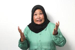 Angry Middle aged Asian women wearing hijab raised her hand while looking at camera photo