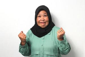 Angry Middle aged Asian women wearing hijab raised her hand while looking at camera photo