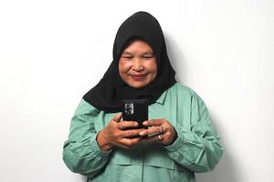 Happy Middle aged Asian women wearing hijaba mobile phone, shopping online, ordering delivery photo