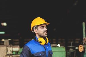 un experto masculino ingeniero o trabajador es trabajando en un industrial planta. trabajadores trabajo con confianza foto