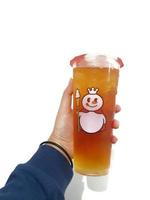 Bekasi, Indonesia in March 2023. Isolated white photo of a hand holding a cup of jasmine Mixue tea.