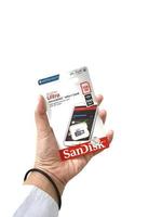 Jakarta, Indonesia in March 2023. Isolated white photo of a hand holding a brand new Sandisk Ultra micro sd memory card