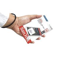 Jakarta, Indonesia in March 2023. Isolated white photo of a hand holding a brand new Sandisk Ultra micro sd memory card