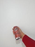 Bekasi, Indonesia in March 2023. Isolated white photo of a hand holding a Rootbeer AW softdrink.