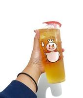Bekasi, Indonesia in March 2023. Isolated white photo of a hand holding a cup of early grey Mixue tea.