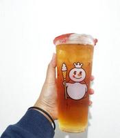 Bekasi, Indonesia in March 2023. Isolated white photo of a hand holding a cup of jasmine Mixue tea.