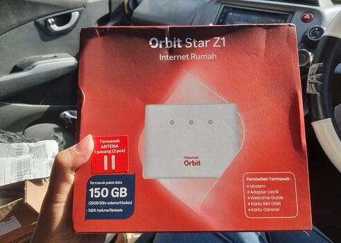 Jakarta, Indonesia in March 2023. A hand is holding a box and a card from a modem with the product Orbit Star Z1 photo