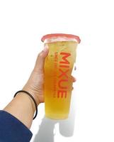 Bekasi, Indonesia in March 2023. Isolated white photo of a hand holding a cup of early grey Mixue tea.