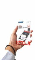 Jakarta, Indonesia in March 2023. Isolated white photo of a hand holding a brand new Sandisk Ultra micro sd memory card