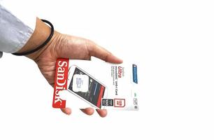 Jakarta, Indonesia in March 2023. Isolated white photo of a hand holding a brand new Sandisk Ultra micro sd memory card