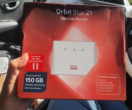 Jakarta, Indonesia in March 2023. A hand is holding a box and a card from a modem with the product Orbit Star Z1 photo