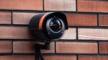 outdoor security camera on a red brick wall photo