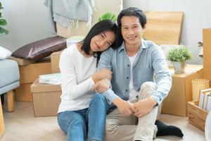 Moving house, relocation. Couple smile and happy after buy new apartment, inside the room was a cardboard box contain personal belongings and furniture. move in the new apartment or condominium photo