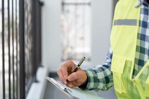 inspector or engineer is inspecting construction and quality assurance new house using a checklist. Engineers or architects or contactor work to build the house before handing it over to the homeowner photo