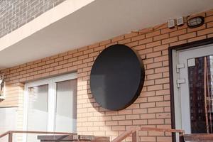 Black round logo on brick wall building exterior for mockup design photo