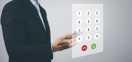 Dialing on virtual telephone keypad with transparent telephone buttons, businessman touch Emergency button of telephone number on screen, Finger touch number on smartphone to make a call, close up, photo