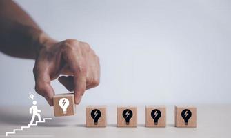 Wooden cube block tower with light bulb icon on white background, Conceptual of creative idea and innovation, New business idea, Creative and new idea, brainstorming creative idea and innovation. photo