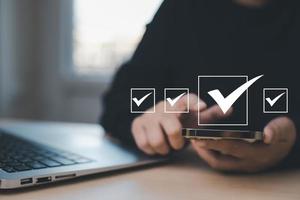 Businessman hold Smartphone with Taking assessment, questionnaire, evaluation, online survey online exam Choosing the right answer in exam by filling out the online survey form,Answer  test questions photo