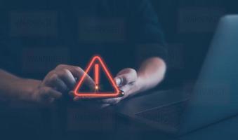 hombre utilizando teléfono inteligente con triángulo precaución advertencia firmar para notificación error y mantenimiento concepto. problema y hackear datos, ciber delito, ciber seguridad foto