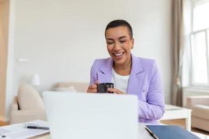 African-american elegant female entrepreneur discussing while having a conference call Portrait of confident ethnicity female employee looking at camera talking on video call in the home office. photo