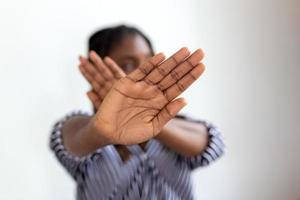 mujer defendiendo sí misma desde ataque. detener. manos extendido. Campaña detener violencia en contra mujer. africano americano mujer elevado su mano para disuadir con Copiar espacio foto